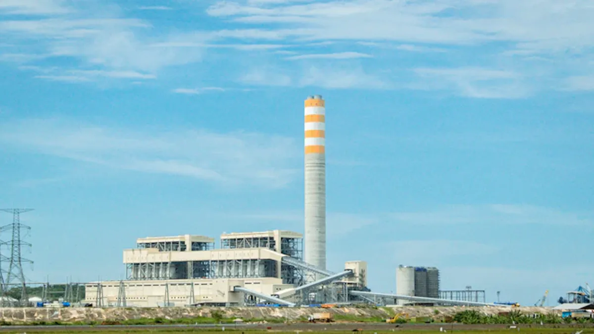 German industrial power plant with smokestacks against cloudy sky during energy crisis